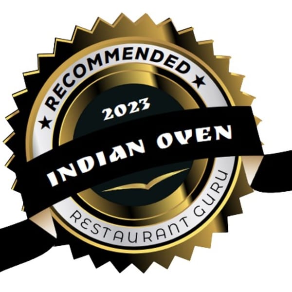 Gold and black 'Recommended 2023 Indian Oven Restaurant Guru' award seal with a ribbon.